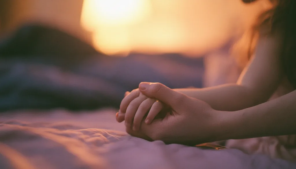 Mão de adulto segurando a mão de uma criança sobre a cama, gesto de acolhimento